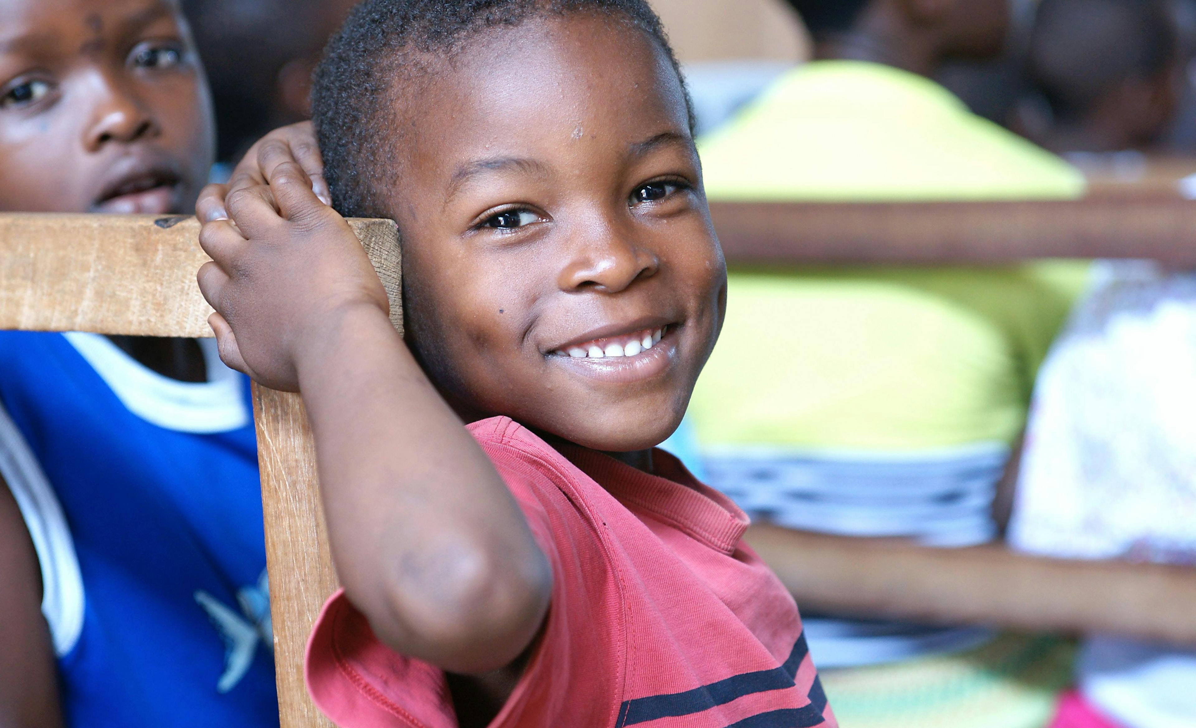 Child smiling in a red shirt Uganda