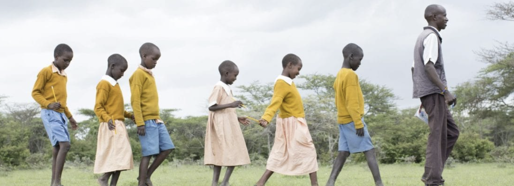 Group of school children walking with a teacher