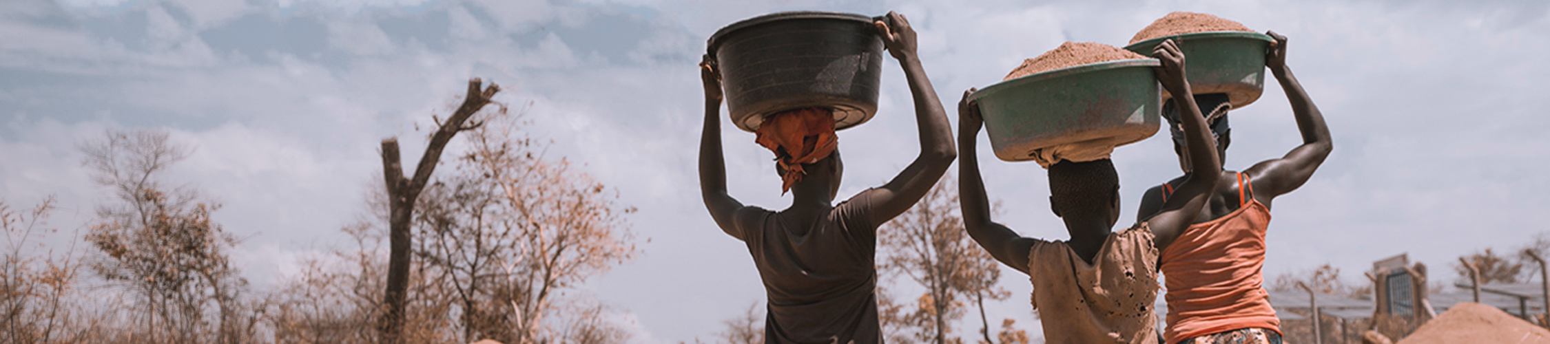 Women walking carrying grain