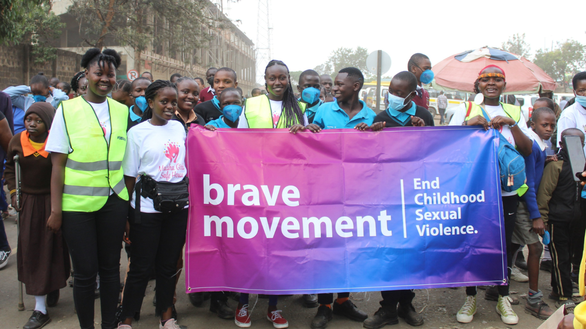 Members of Brave Movement Kenya hold a banner that says "Brave Movement to End Childhood Sexual Violence."