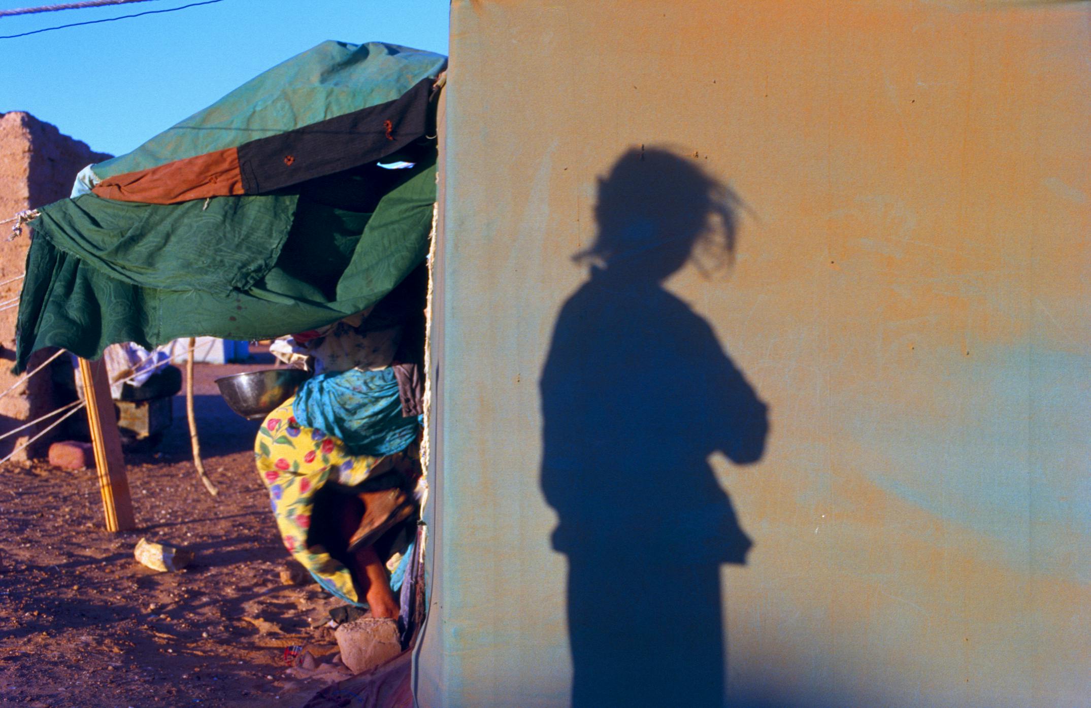 Girl in refugee camp shadow
